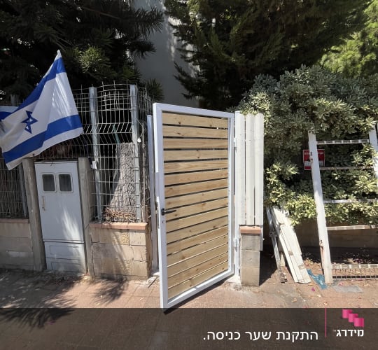 שער עץ פתוח עם מסגרת מתכת לבנה